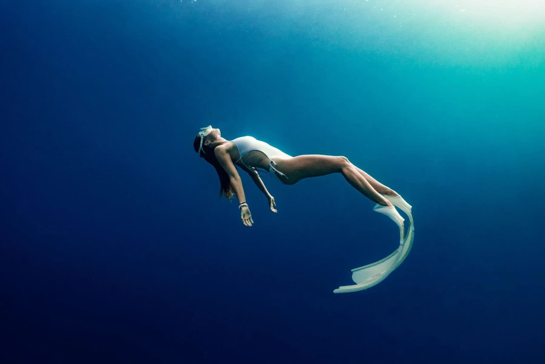 A freediver in deep blue water