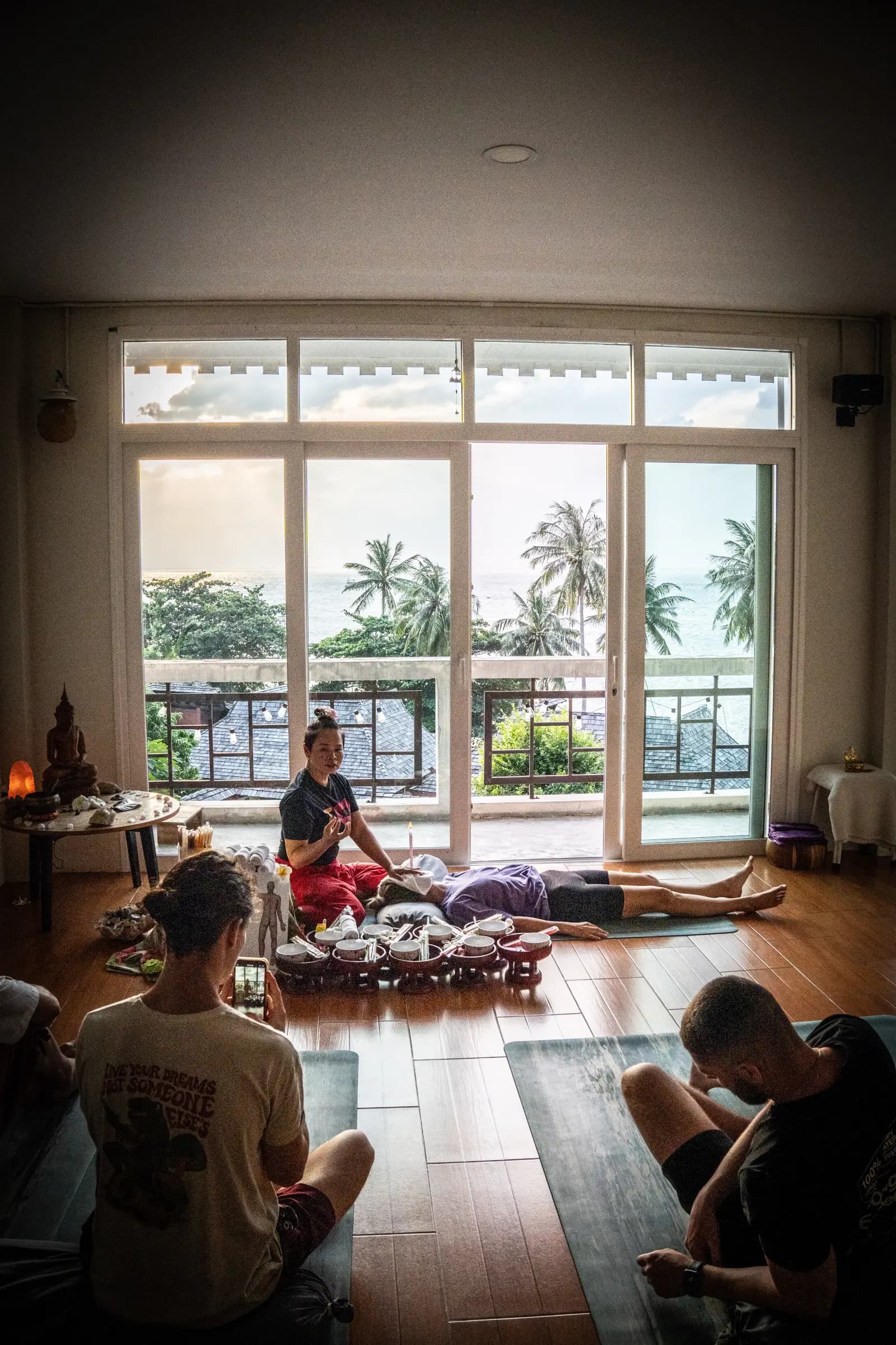 Students watching a Thai Massage demonstration in the sea-view shala