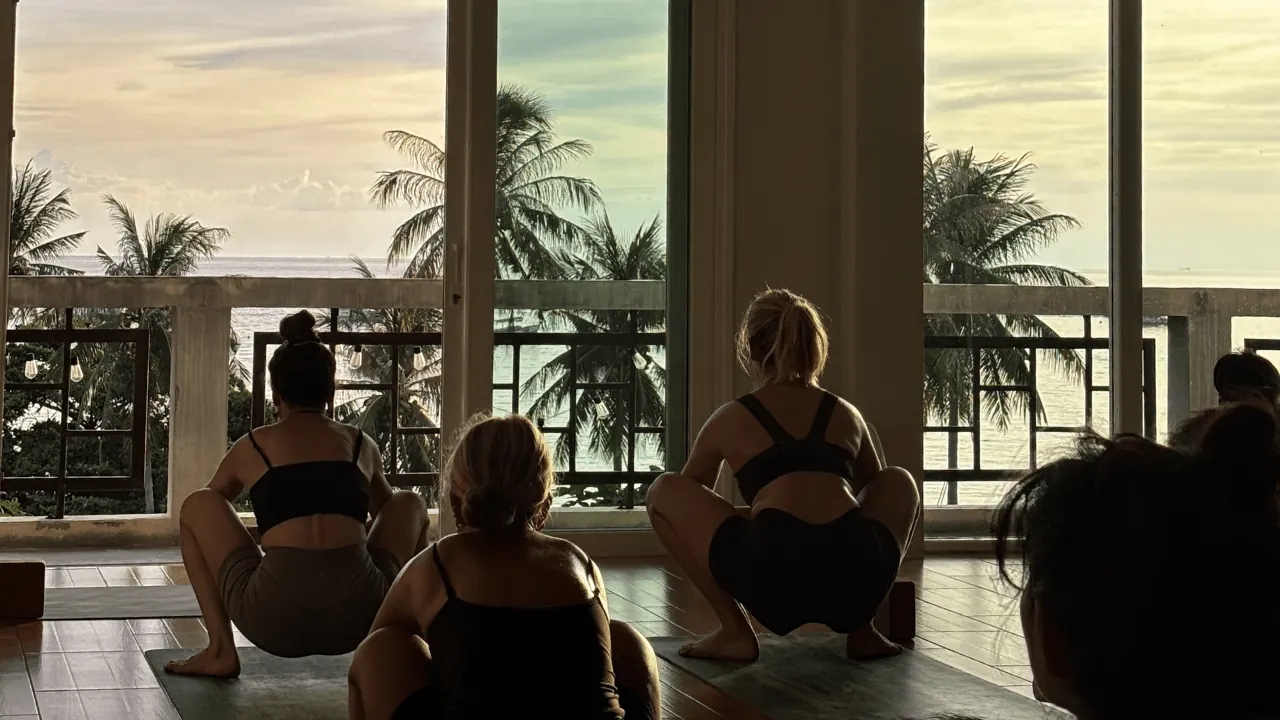 Yoga students practising together in Blue Chitta's sea-view studio in Koh Tao