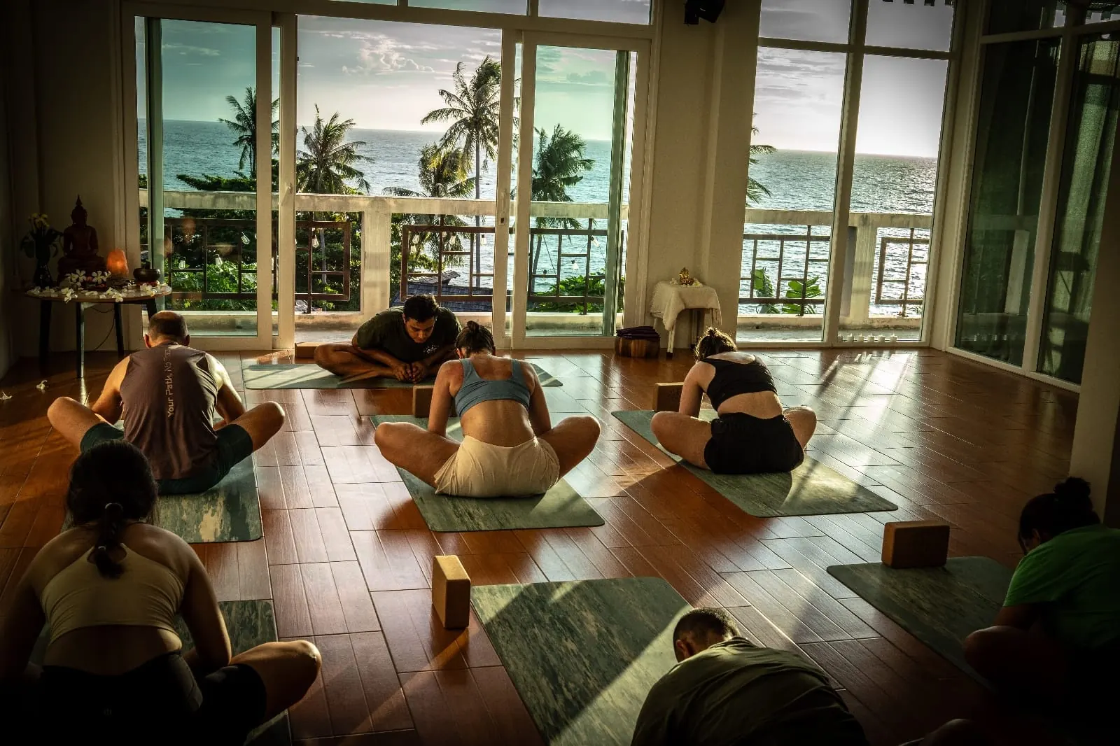 A yoga class stretching together in Blue Chitta's studio overlooking the sea