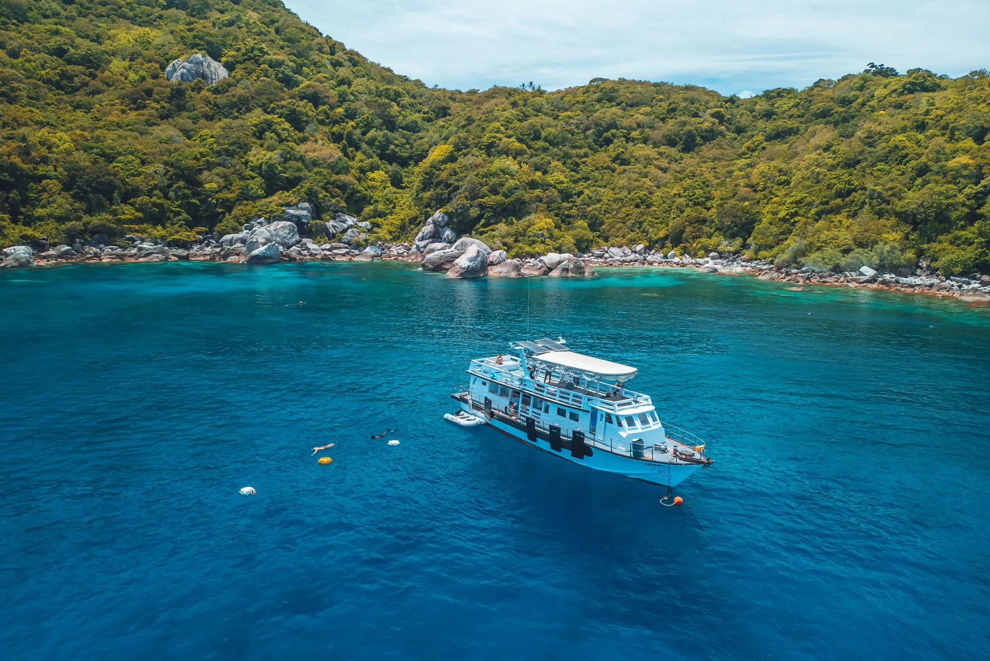 The Blue Chitta boat in a green bay off Koh Tao