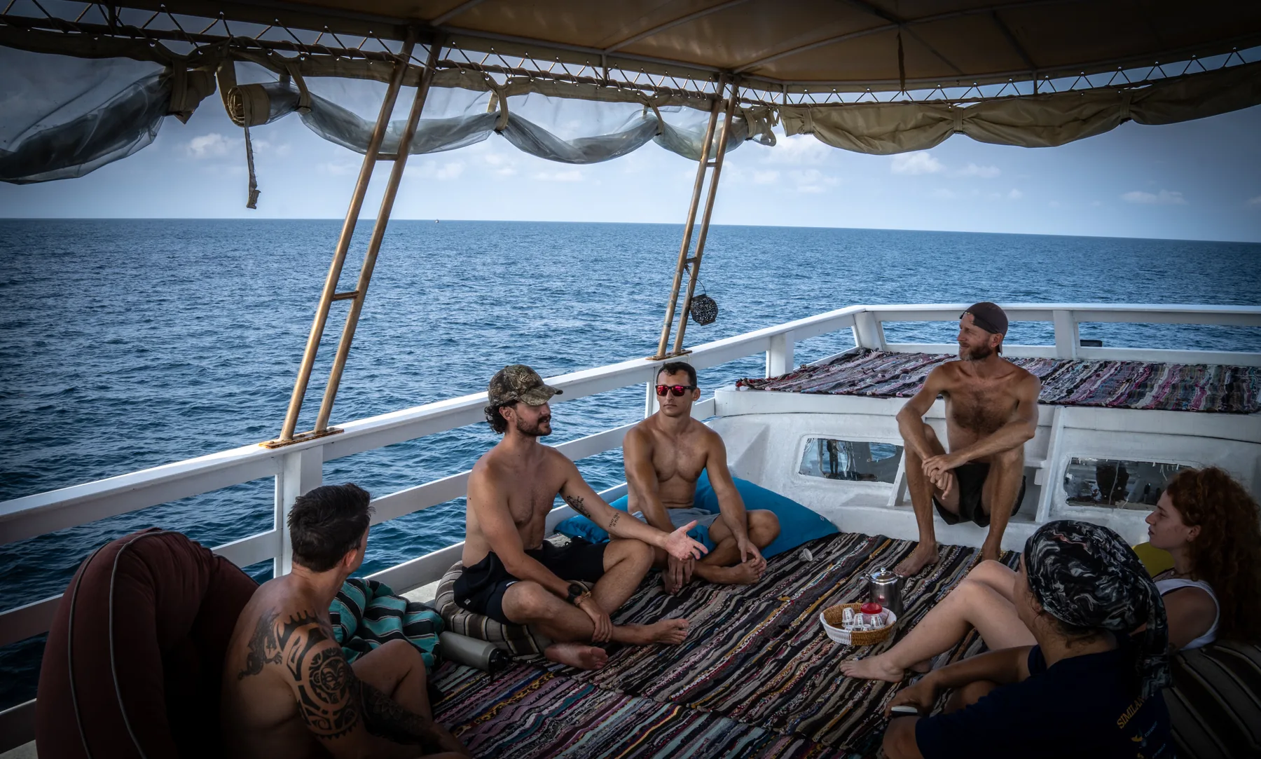 Divers sitting along the deck of the Blue Chitta boat