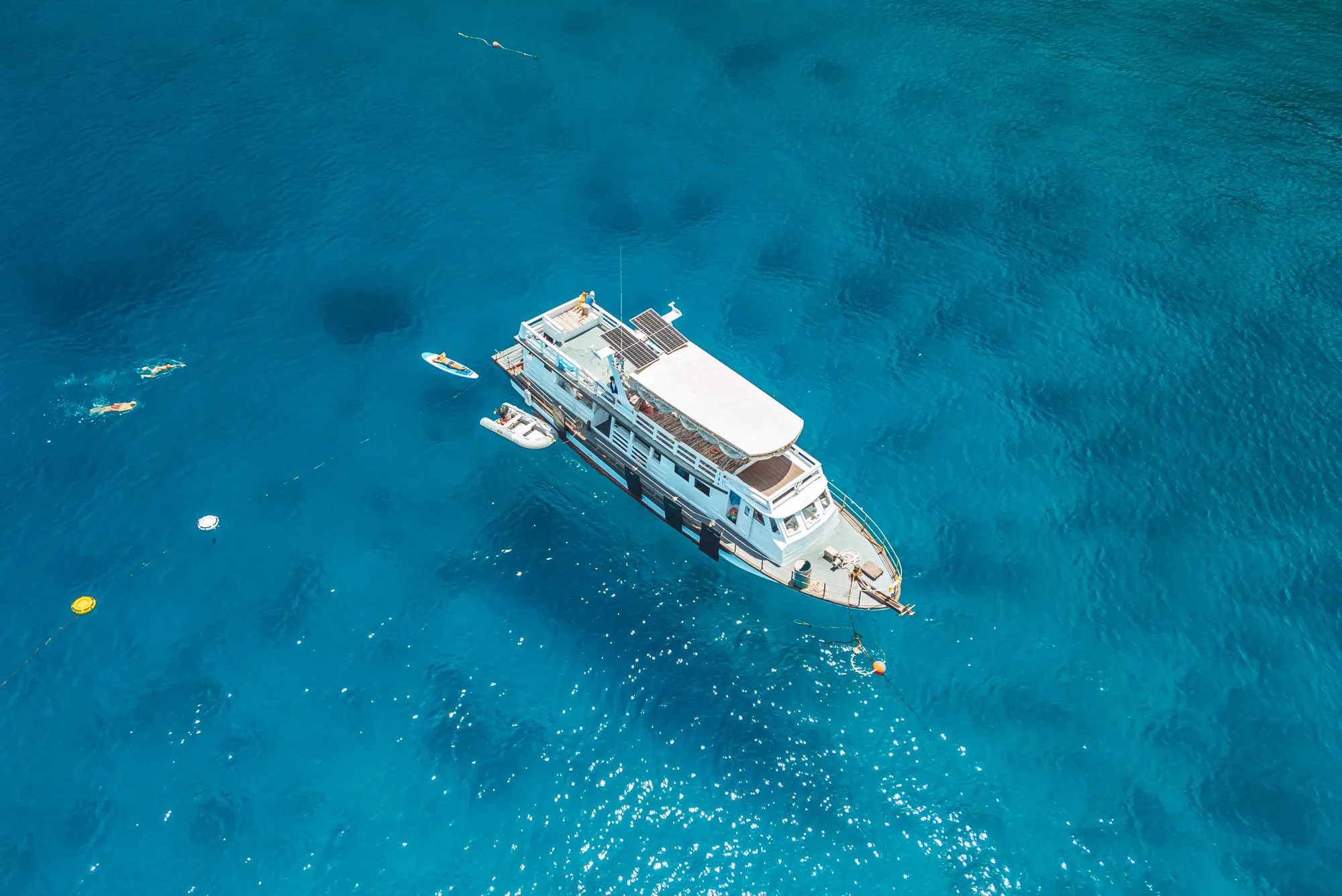 The Blue Chitta freediving boat anchored over turquoise water, seen from above