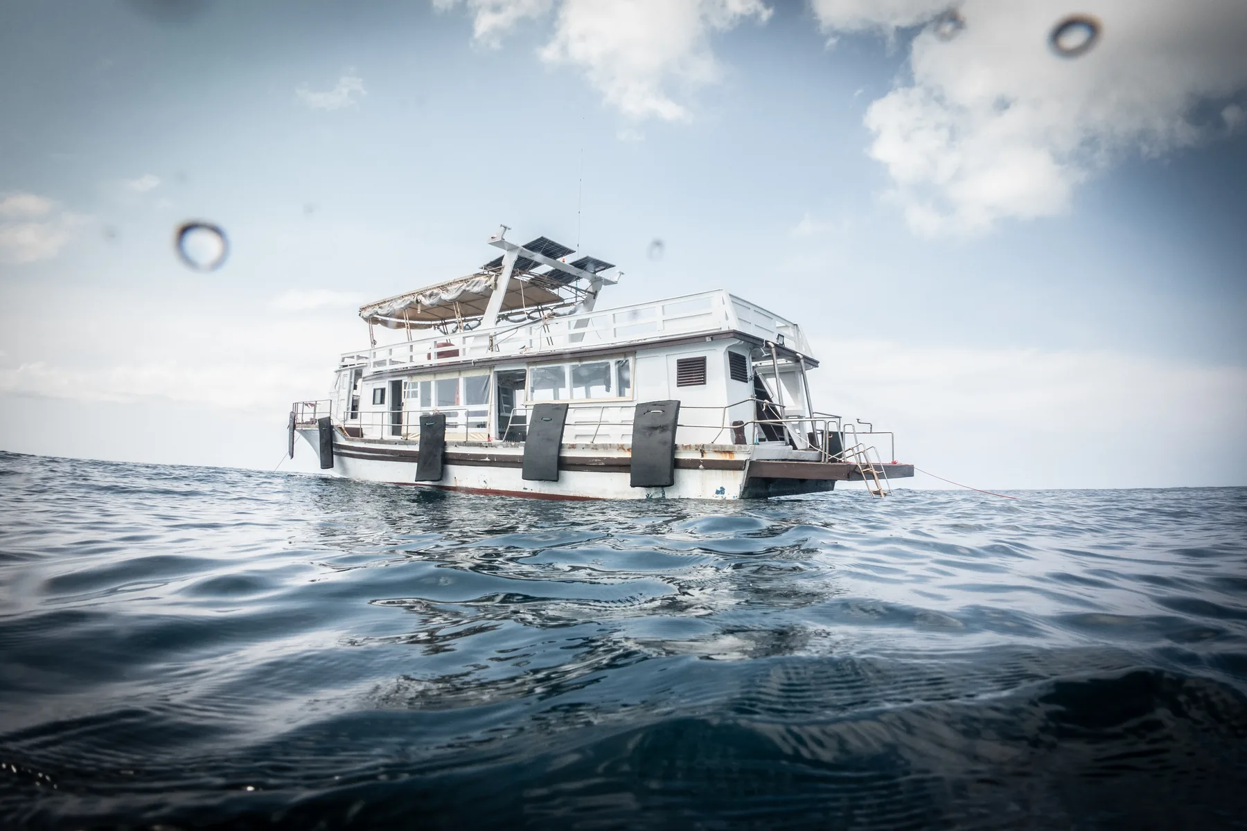The Blue Chitta dive boat on open water under a wide sky